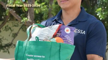 The cover of the County of Orange Social Services Agency's 2023-2024 Annual Report features an employee holding a bag of groceries.