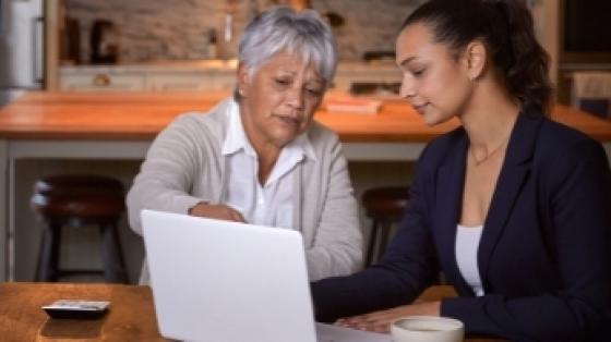 An older woman and younger woman look at a computer screen