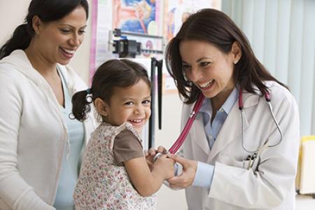 Smiling doctor, mother and daughter in doctor's office.