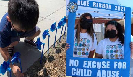 Boy playing in flower garden and two girls holding "No excuse for child abuse" sign.