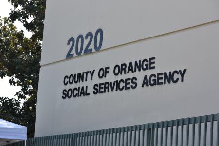 Photo of the building address at 2020 W. Walnut St. in Santa Ana. Features a sign saying "County of Orange Social Services Agency"